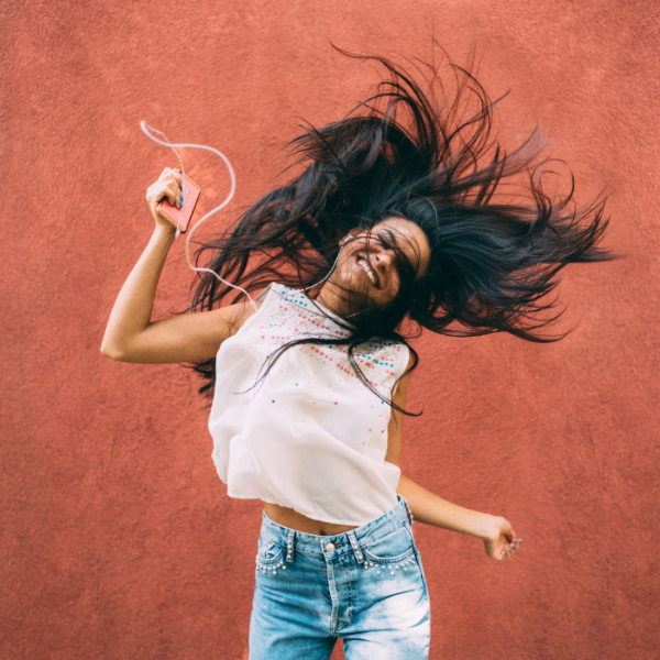 Vrouw danst op muziek als ontspannende activiteit om stress te verminderen.