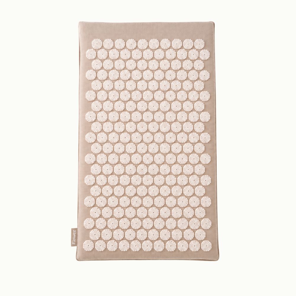 Zandkleurige Flowee Eco spijkermat met witte spikes.