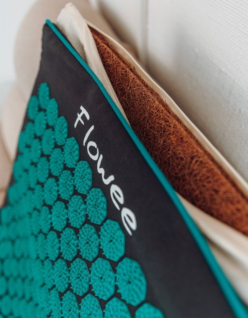 Close-up van een Flowee ECO spijkermat met zeegroene spikes en natuurlijke kokosvulling.