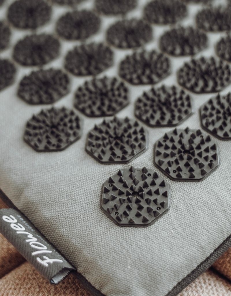 Close-up van de zwarte spikes op een groene Flowee spijkermat voor ontspanning tijdens de overgang.
