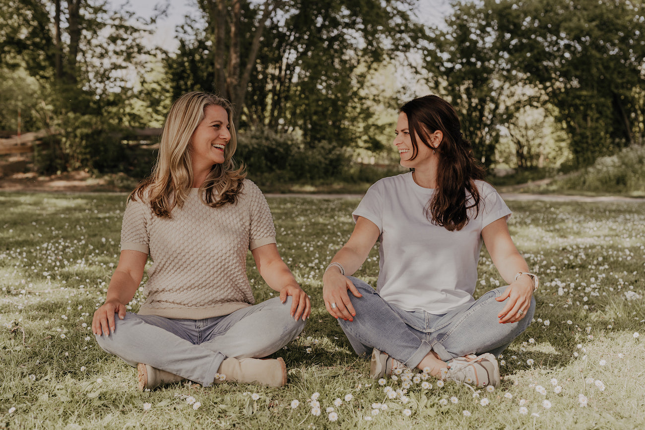 Tamara en Manon zitten in een meditatiehouding op het gras