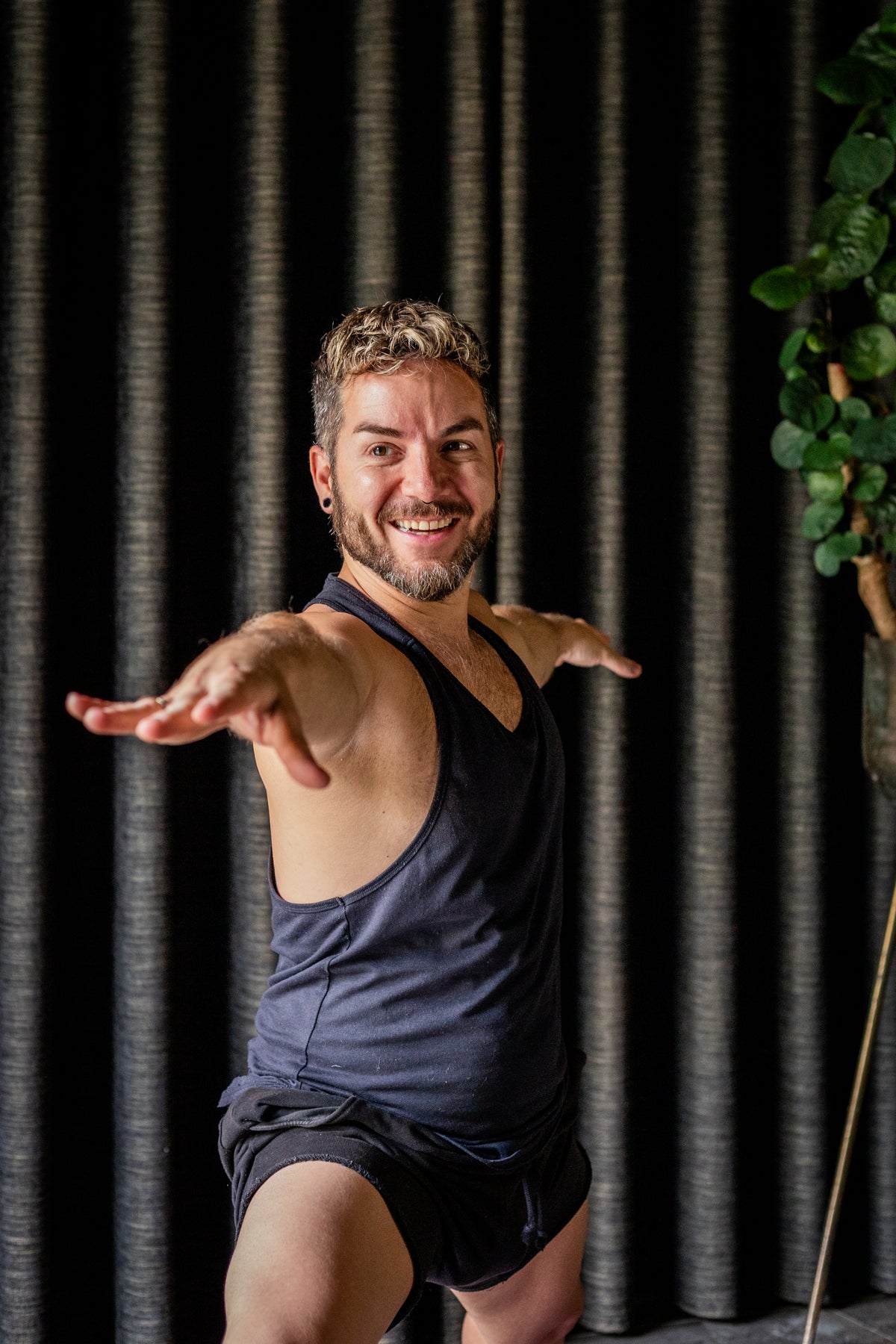 Yogadocent Danny Benaets van Yogastudio Het Lichtpunt staat lachend in de krijgerhouding in zijn studio
