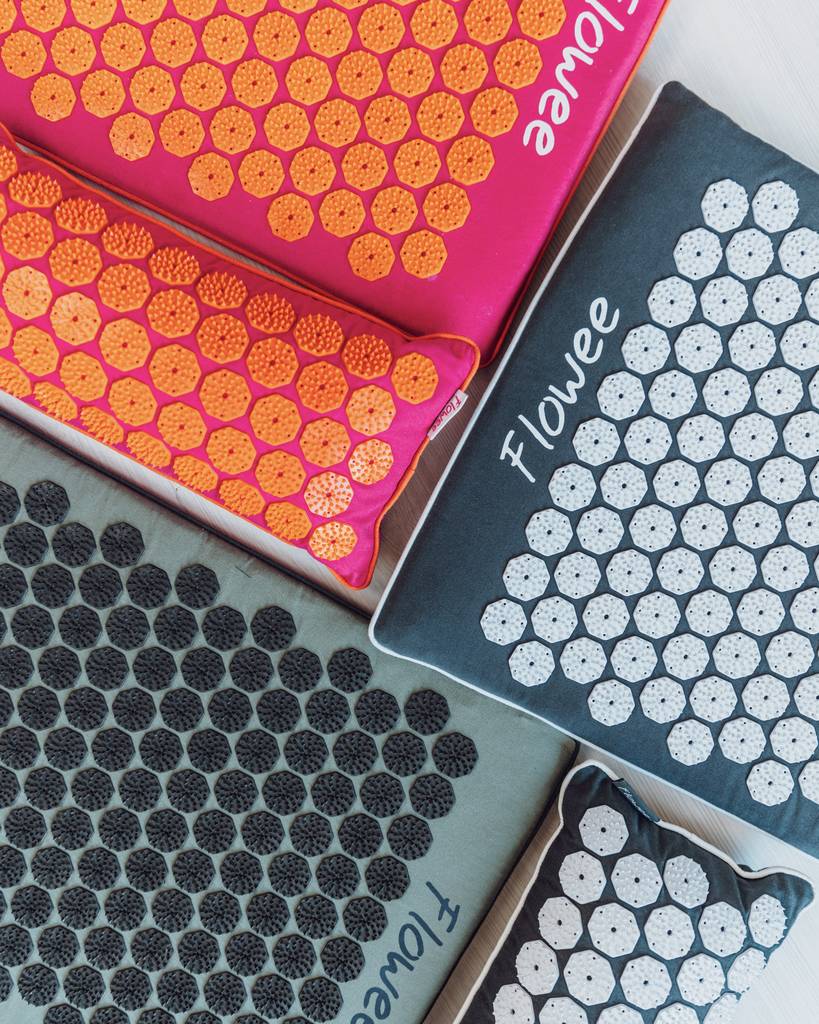 Verschillende kleuren ECO spijkermatten van Flowee naast elkaar op de vloer.