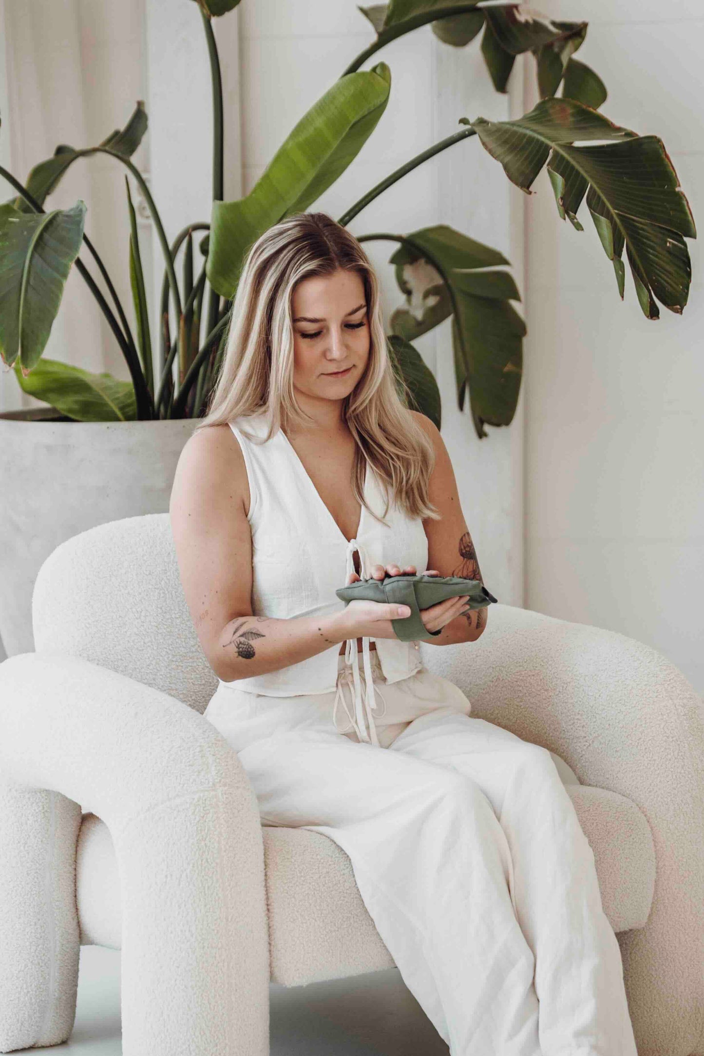 Vrouw houdt een groene Flowee massagehand vast en bekijkt de spikes.