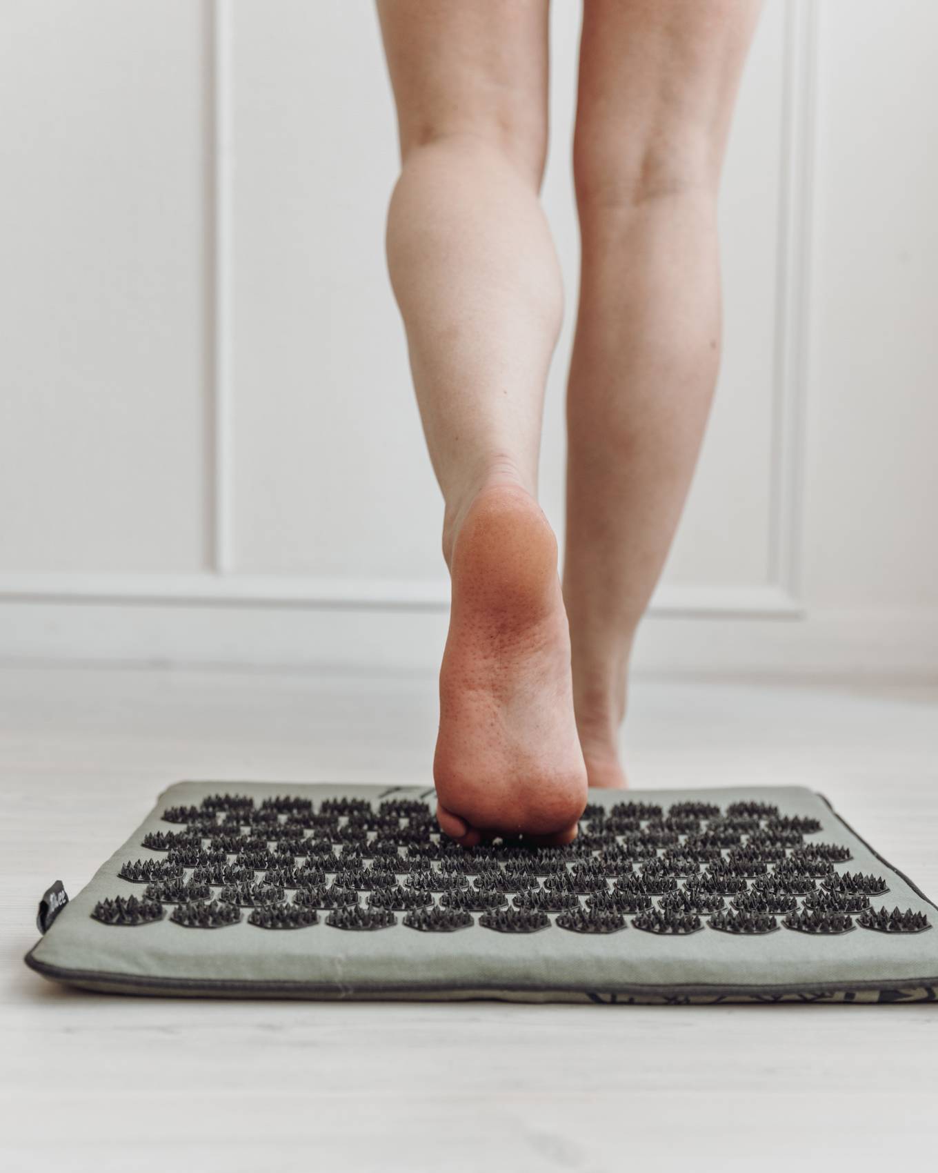 Persoon loopt van het kleine spijkermatje af met het resultaat van de drrukpunten onder de voet.