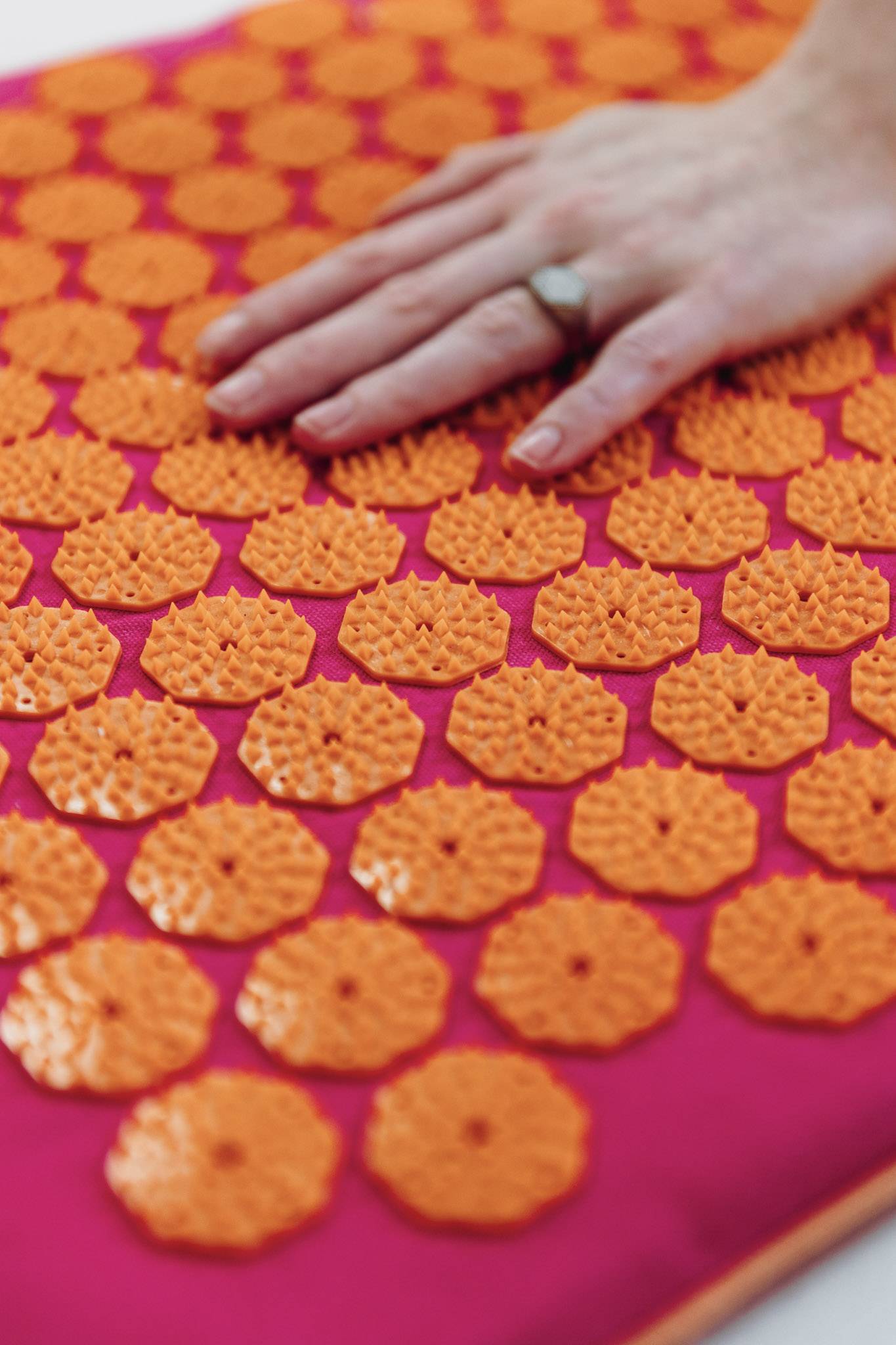 Een hand gaat over de spikes van een spijkermat
