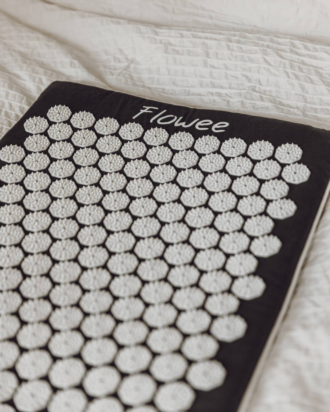 De grijze spijkermat met witte spikes van Flowee